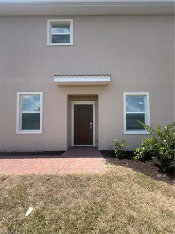 View of exterior entry featuring a lawn