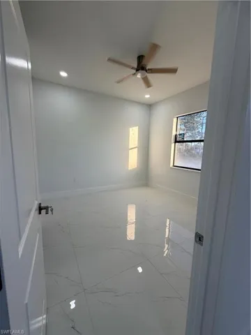 Unfurnished room with recessed lighting, light marble finish floors, and a ceiling fan