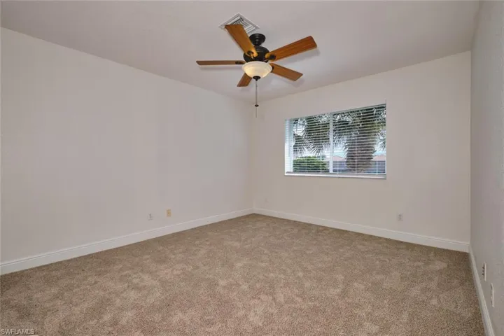 Unfurnished loft featuring light colored carpet and a ceiling fan