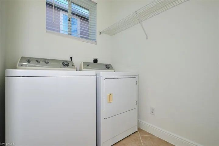 Laundry room with washer and dryer and light tile patterned flooring