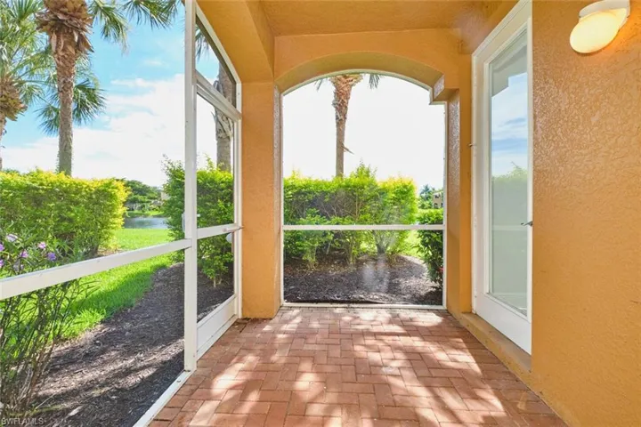 Unfurnished sunroom with brick floors, a water view, and plenty of natural light