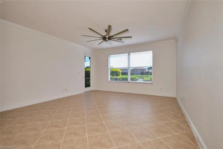 Unfurnished room featuring crown molding, light tile patterned floors, and a ceiling fan