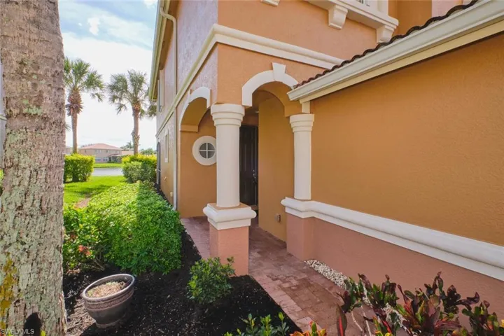 Doorway to property featuring stucco siding and covered porch