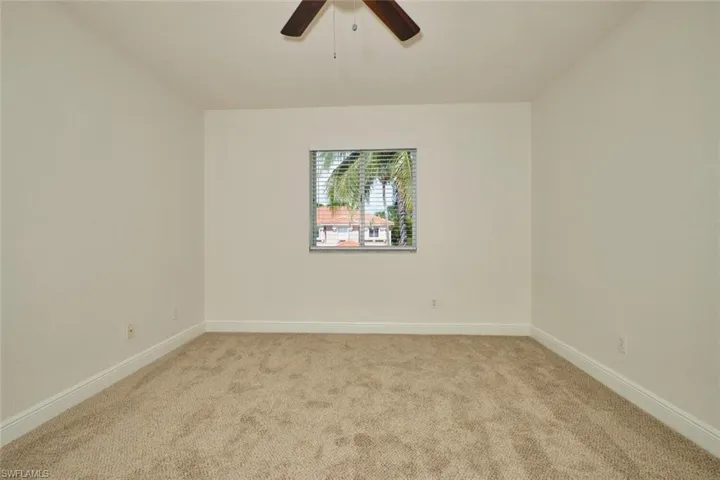 Spare room with light carpet and a ceiling fan