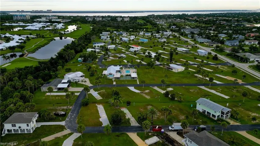 Aerial view of property and surrounding area featuring a large body of water and nearby suburban area