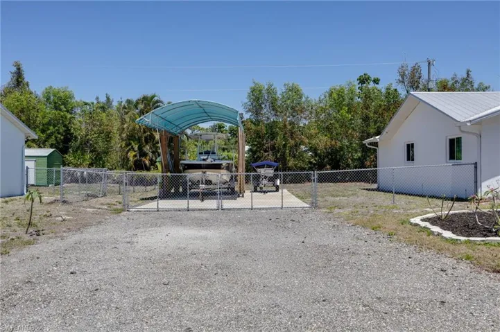 View from the street of the newer fence and covered boat storage