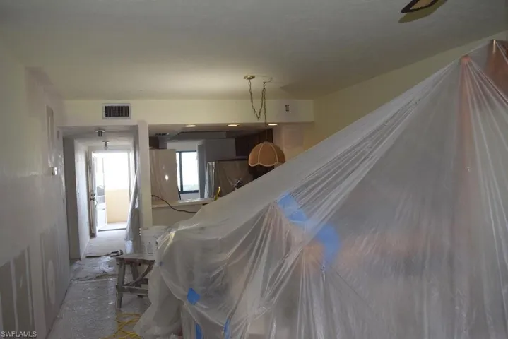 VIEW FROM LIVING AREA TOWARDS DINING, KITCHEN AREA.  UNIT ENTRANCE SHOWN AT LEFT REAR.  ENTRANCE TO OWNER'S SUITE IS TO LOWER LEFT.  ENTRANCE TO GUEST BEDROOM AND GUEST BATH IS TO REAR UPPER LEFT.