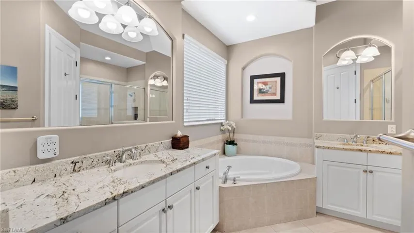 Master Bathroom with tile patterned flooring, vanity, and separate shower and tub