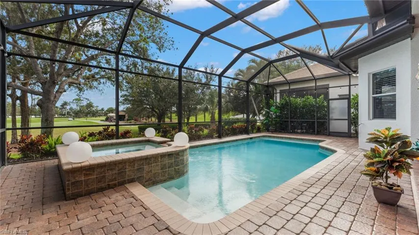 View of pool with an in ground hot tub, a patio area, and a lanai