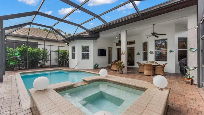 View of swimming pool with an in ground hot tub, a patio, ceiling fan, and a lanai
