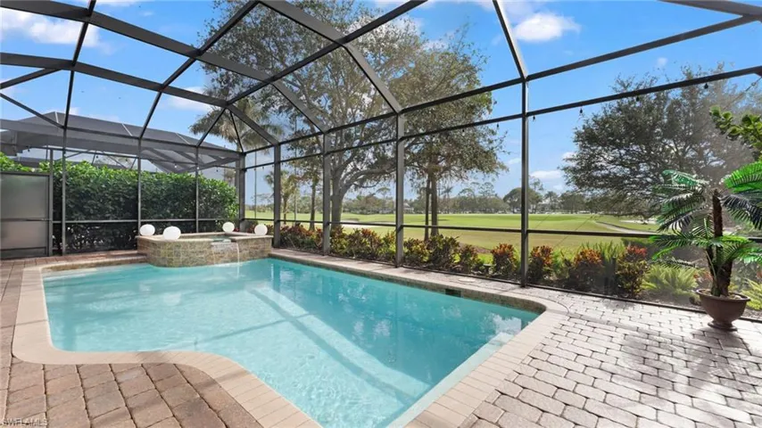 View of pool featuring an in ground hot tub, a patio, and glass enclosure