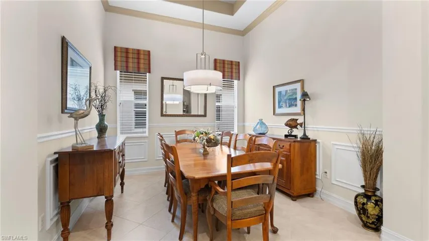 Dining space with a raised ceiling, crown molding, and a towering ceiling