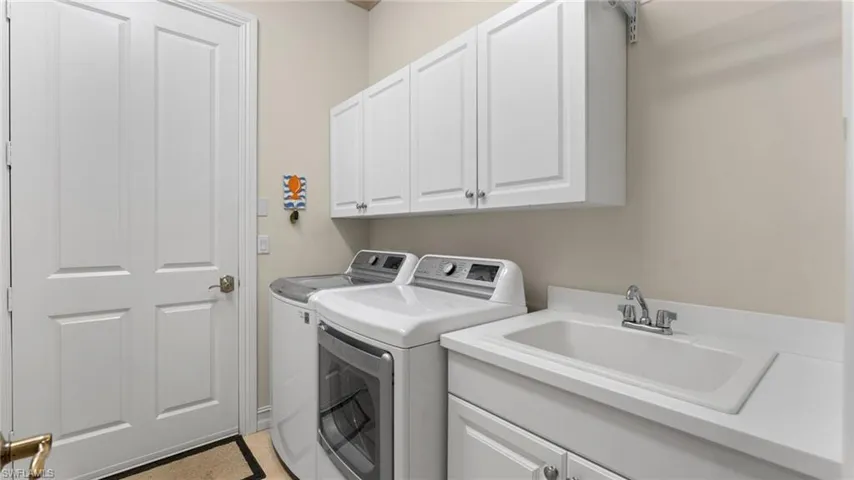 Laundry room with washer and dryer, cabinets, and sink