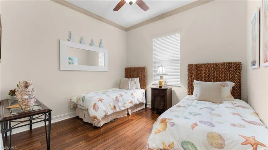 Bedroom 3 with ceiling fan, crown molding, and dark wood-type flooring