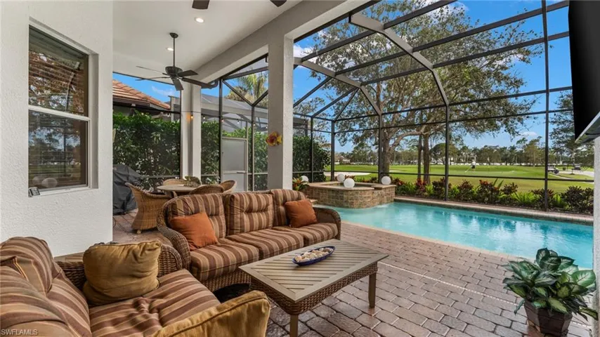 View of swimming pool with glass enclosure, an outdoor living space, ceiling fan, and a patio