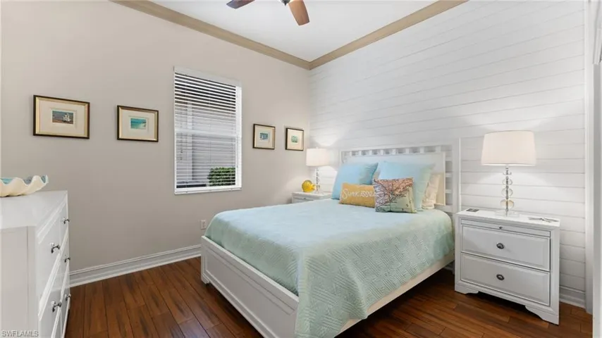 Bedroom 2 with ornamental molding, ceiling fan, and dark wood-type flooring