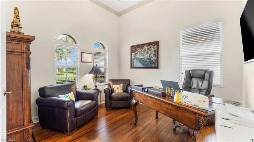 Office space with dark hardwood / wood-style flooring and ornamental molding