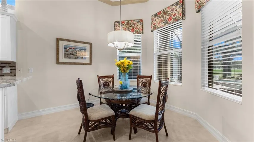 Tiled dining space featuring crown molding and a healthy amount of sunlight
