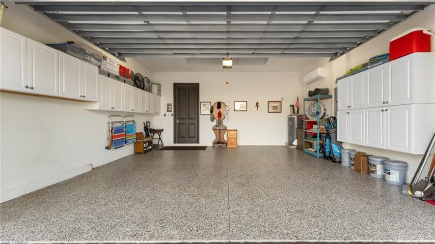 Garage featuring a wall mounted split AC Ultraviolet equipped house AC and a garage door opener