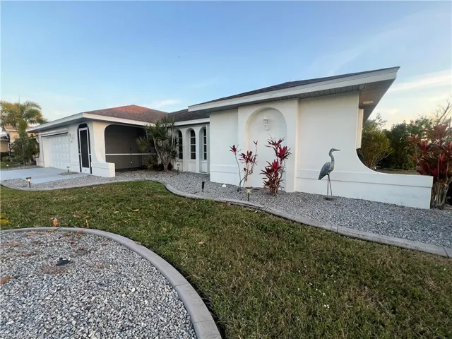 Ranch-style home with a garage and a front lawn