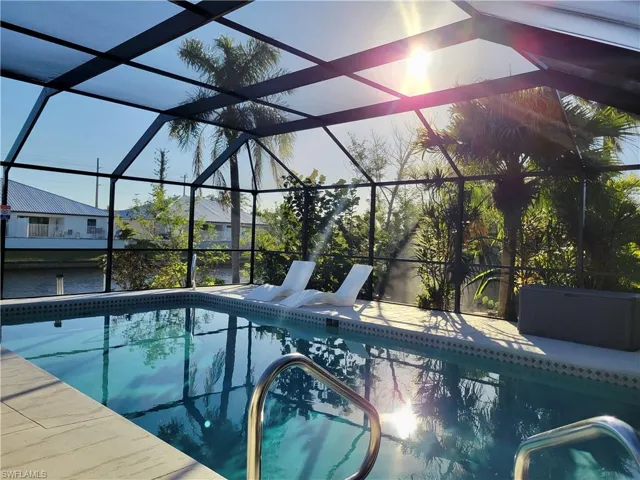 View of pool featuring a patio area and enclosed in Lani. View of canal leading to gulf can be seen just beyond the pool.