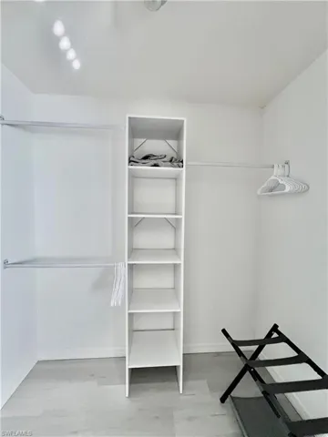Bedroom 2 spacious walk in closet featuring light hardwood / wood-style floors