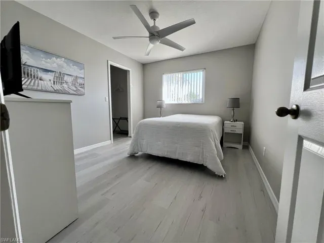 Bedroom 2 with walk in closet featuring light hardwood / wood-style flooring and ceiling fan