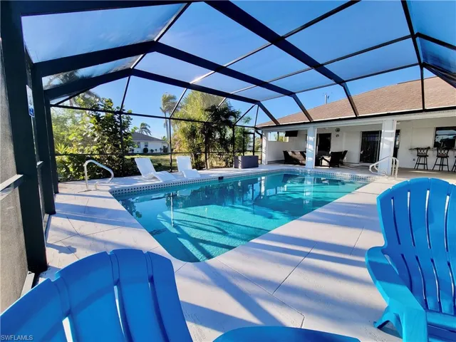 View of swimming pool featuring a patio area and glass enclosure