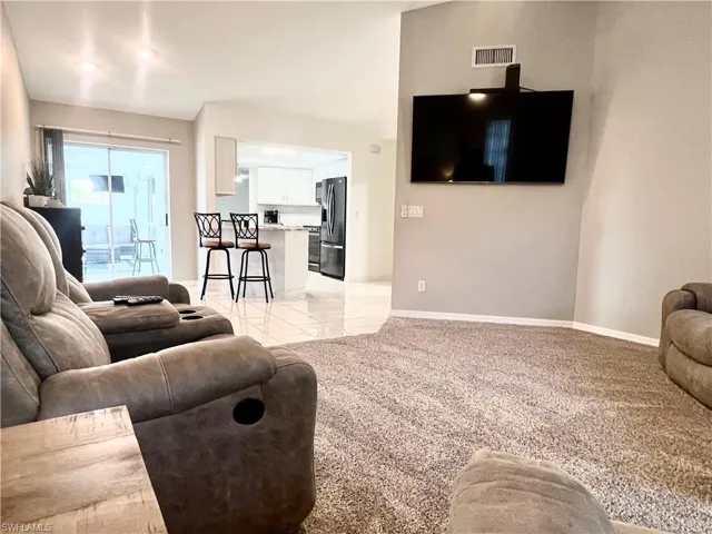 Living room with cathedral ceiling and view to kitchen pool and dining