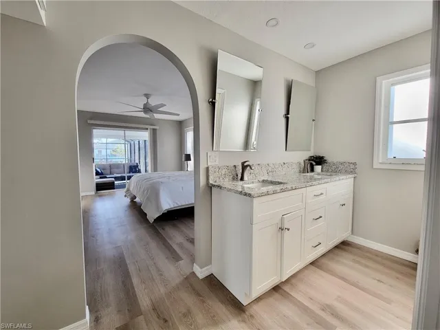 Bathroom with wood-type flooring, vanity, and ceiling fan