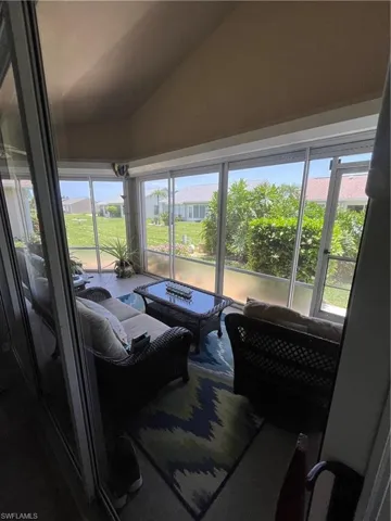 Enclosed screened patio featuring a vaulted ceiling and expansive exterior views