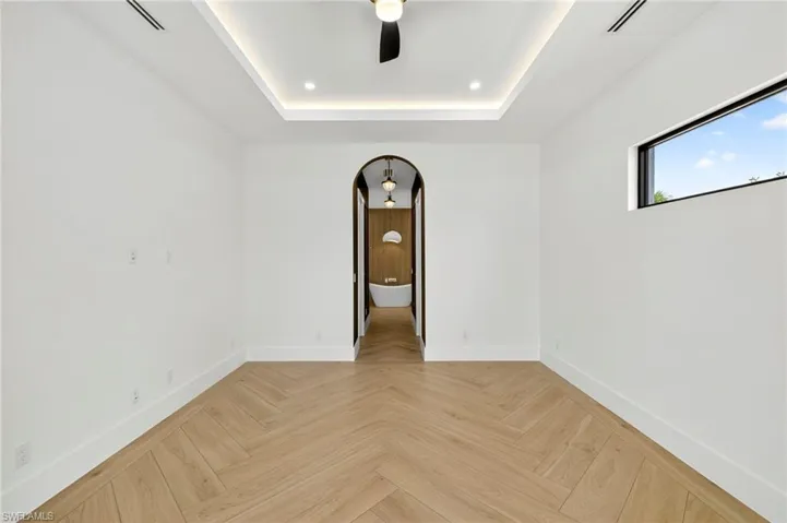 Empty room with a ceiling fan and a raised ceiling