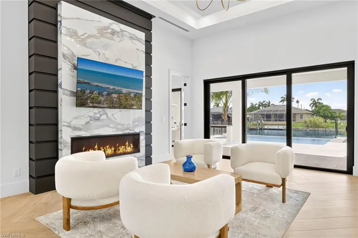 Living area featuring a premium fireplace, a towering ceiling, and a chandelier