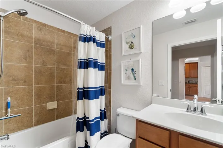 Full bathroom with shower / bath combination with curtain, vanity, and toilet