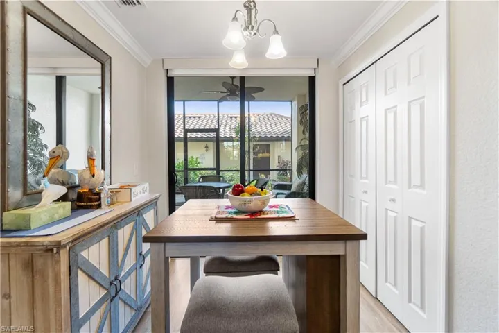 Dining room featuring an inviting chandelier, ornamental molding, and light wood-type flooring