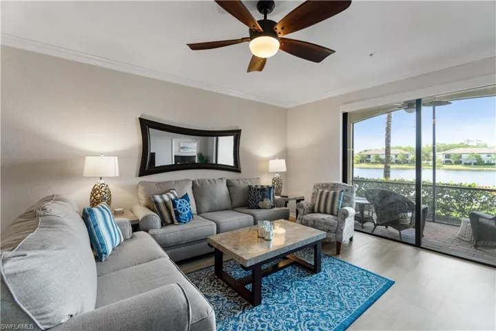 Living room featuring a healthy amount of sunlight, wood-type flooring, ceiling fan, and a water view