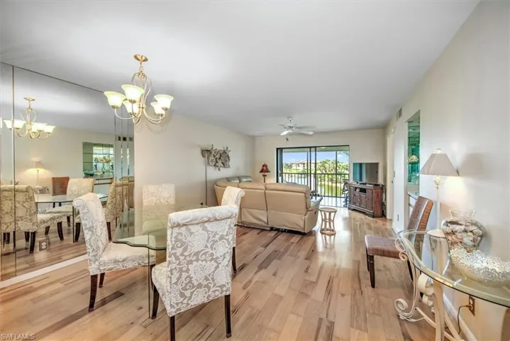Dining space with ceiling fan with notable chandelier and light wood-type flooring