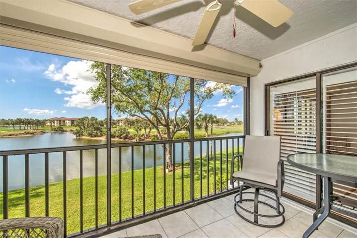 Sunroom / solarium featuring a water view, plenty of natural light, and ceiling fan