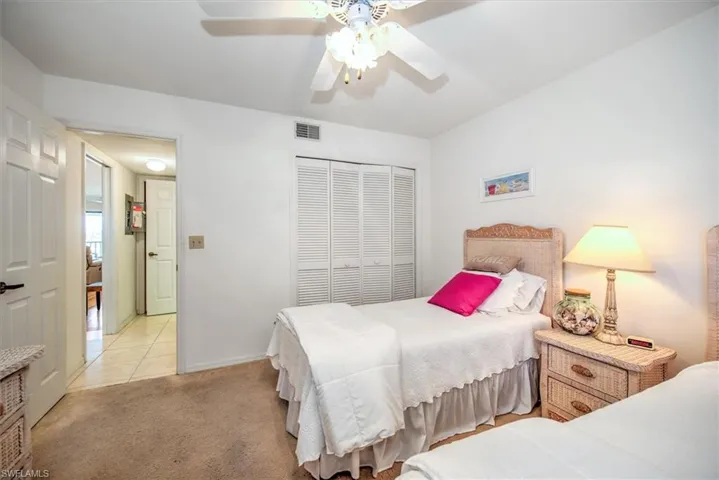 Bedroom with light colored carpet, a closet, and ceiling fan