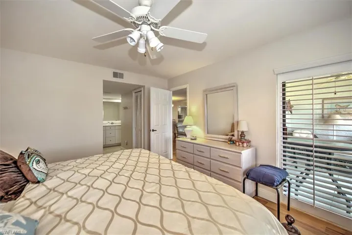 Bedroom with ceiling fan, wood-type flooring, and connected bathroom
