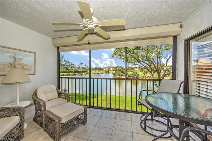 Sunroom / solarium with a wealth of natural light, a water view, and ceiling fan