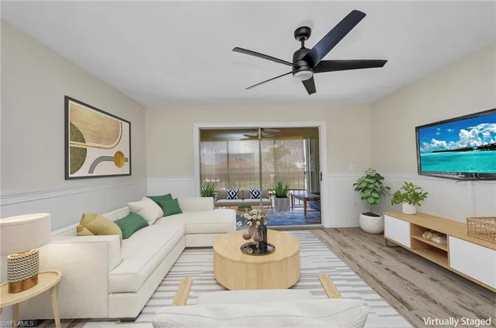 VIRTURALLY STAGED  Living room featuring wainscoting, luxury vinyl flooring, and ceiling fan