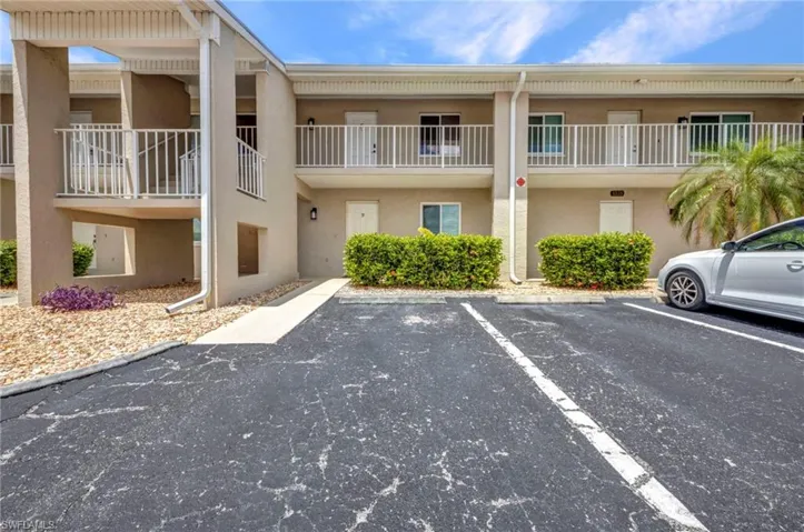 View of apartment building / complex with uncovered parking