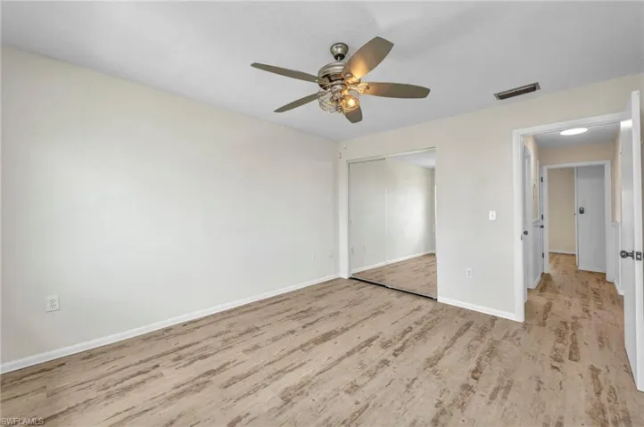 Unfurnished bedroom featuring a ceiling fan, a closet, and light wood finished floors