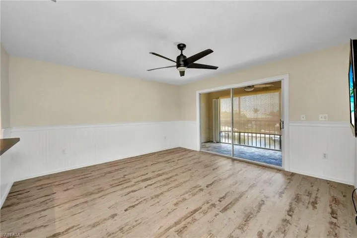 Great room  with wainscoting, luxury vinyl and a ceiling fan
