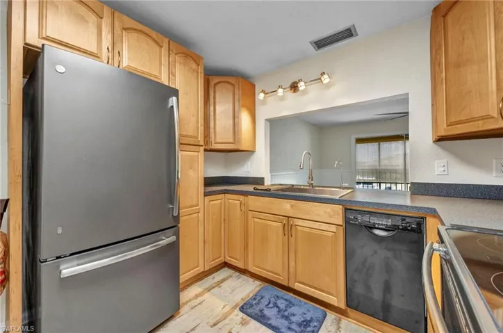 GE Monogram appliance suite with Bosch dishwasher, maple cabinetry and luxury vinyl flooring