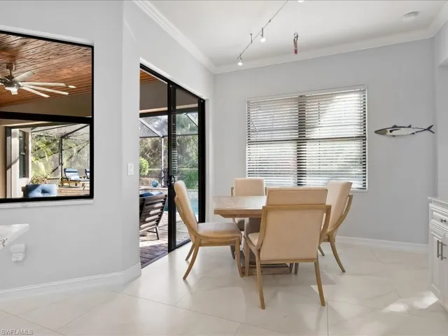 Dining room with ornamental molding, rail lighting, and a ceiling fan