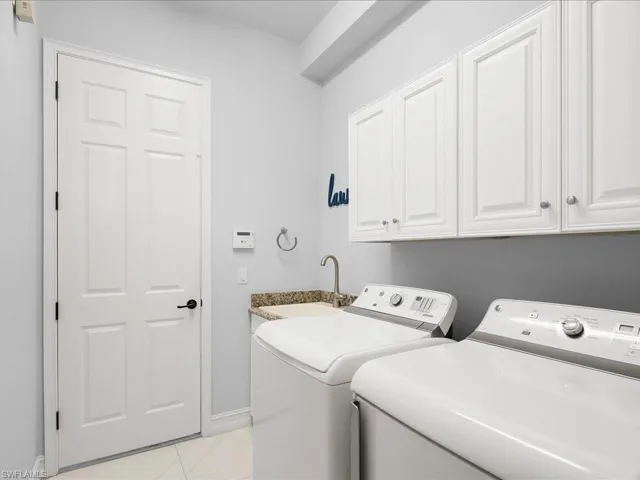 Laundry area featuring separate washer and dryer and a sink