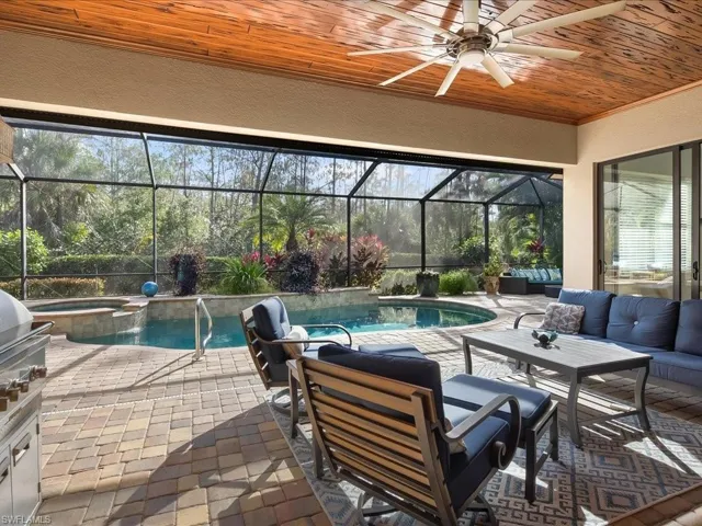 View of patio featuring a sunroom, a lanai, a ceiling fan, outdoor lounge area, and a pool with connected hot tub