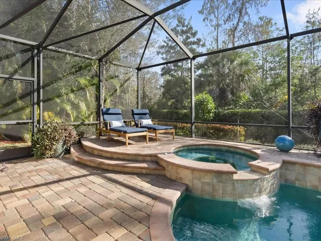 View of patio featuring a lanai, a sunroom, and a pool with connected hot tub